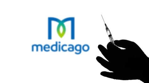 BRAZIL - 2021/04/12: In this photo illustration the medical syringe is seen with Medicago company logo displayed on a screen in the background. (Photo Illustration by Rafael Henrique/SOPA Images/LightRocket via Getty Images)
